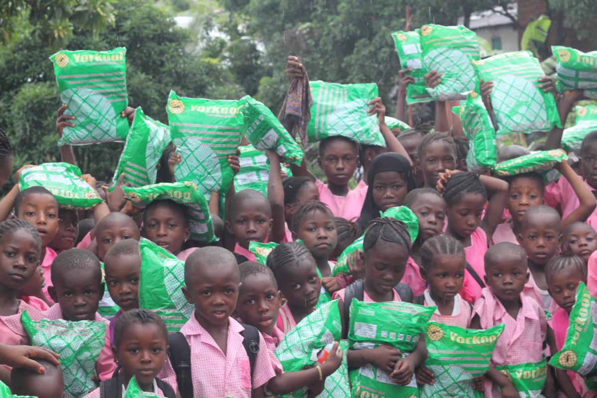 Group of children holding donated mosquito nets to stop malaria