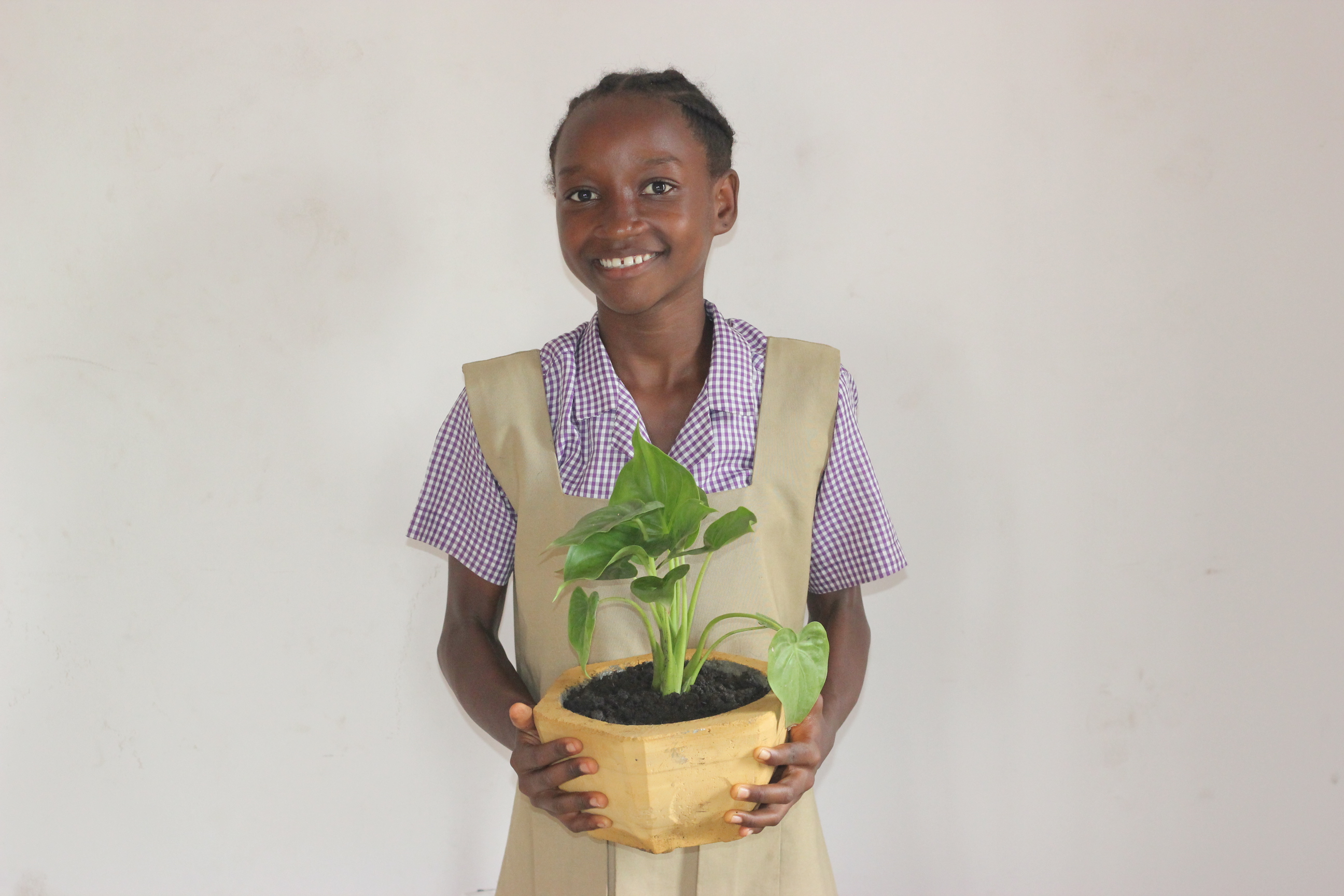 School girl holding plant 